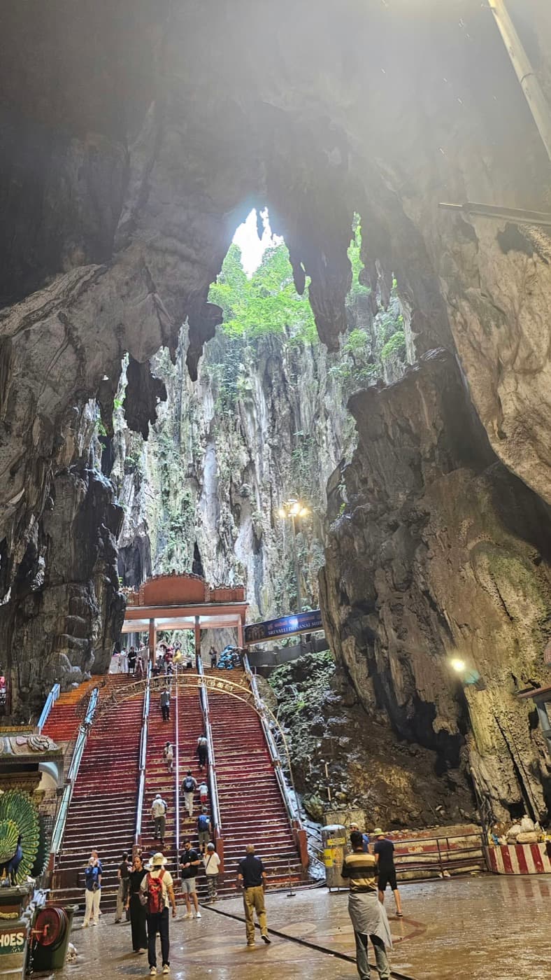 Stairs leading up inside a huge limestone cave, open to the sky at the top