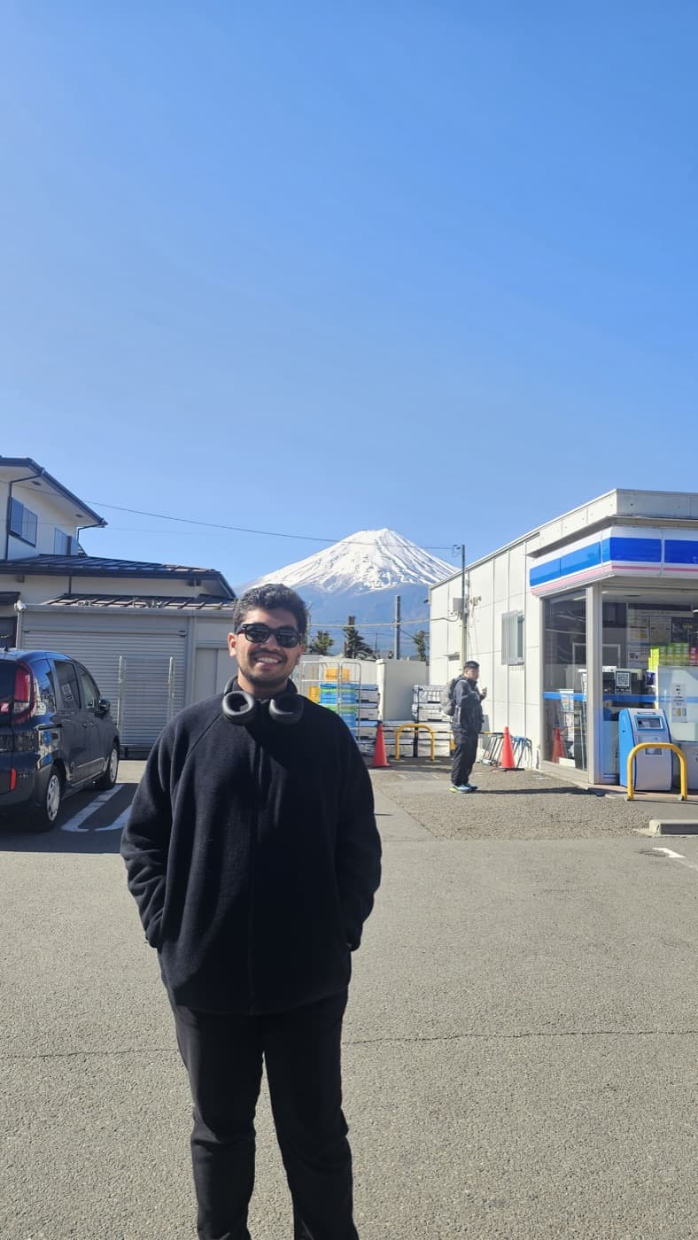 Ishan standing in a street with Mount Fuji behind him